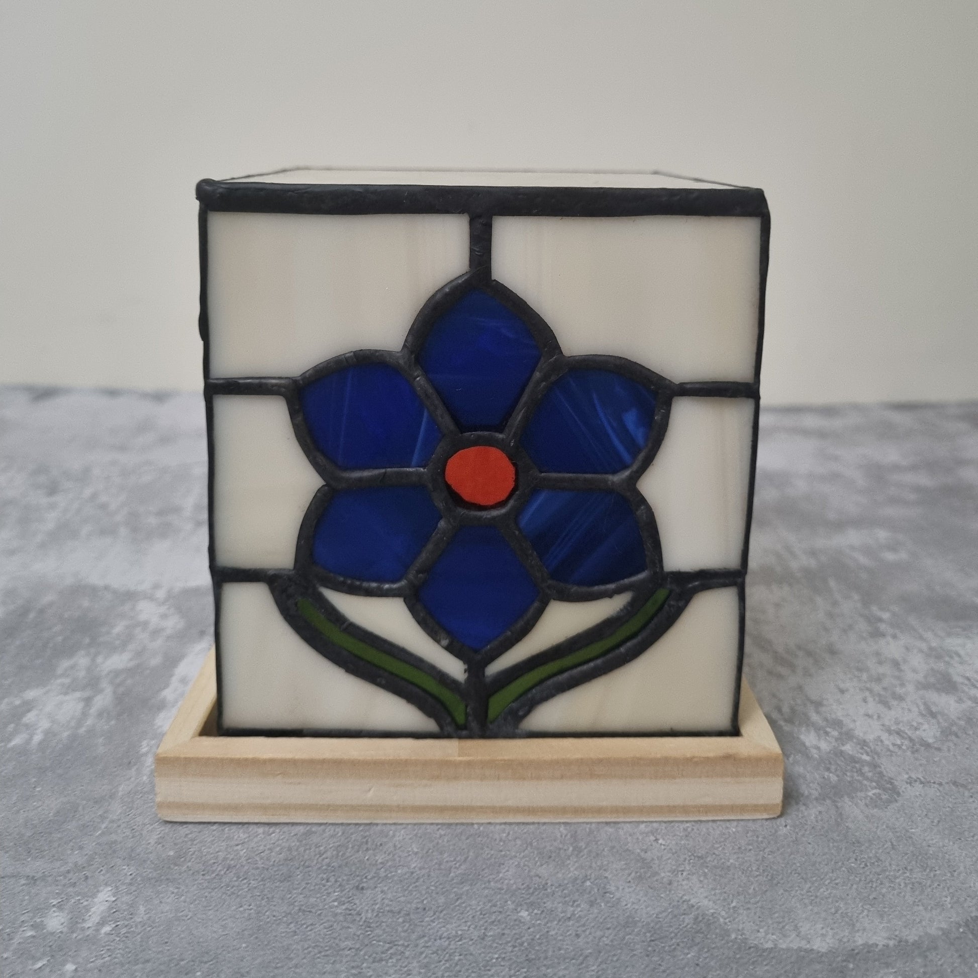 Stained glass panel with a blue flower design on a white background
