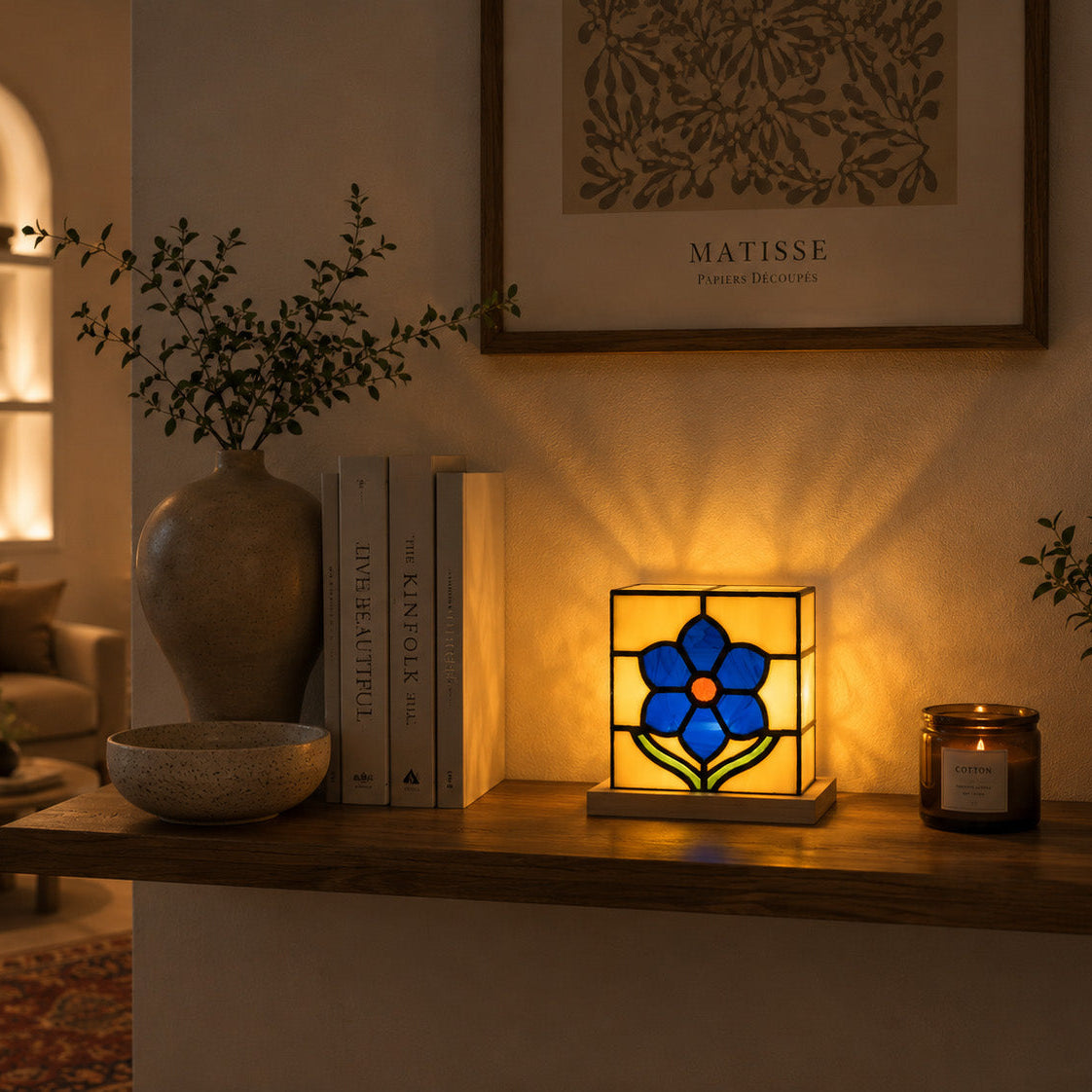 Decorative lamp with stained glass design on a wooden surface in a cozy living room.