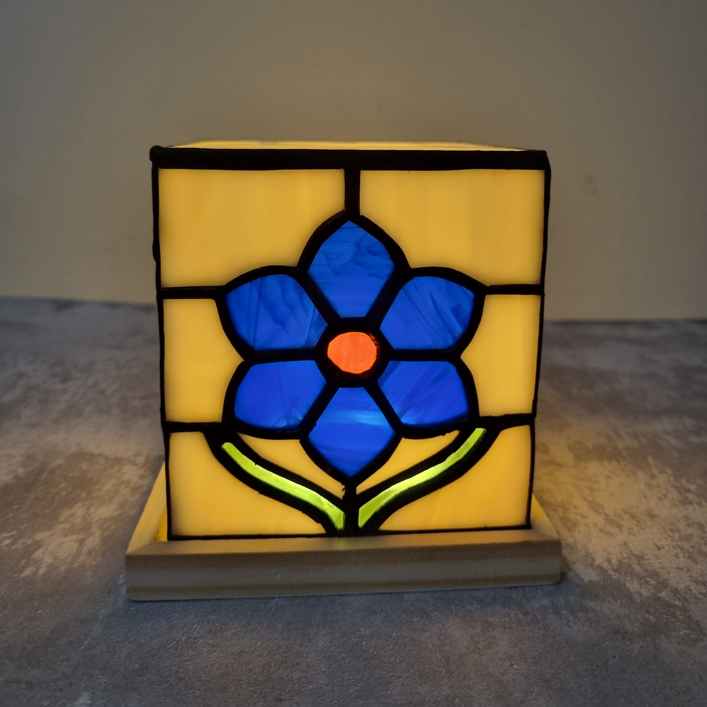 Decorative table light with stained glass design of a blue flower 