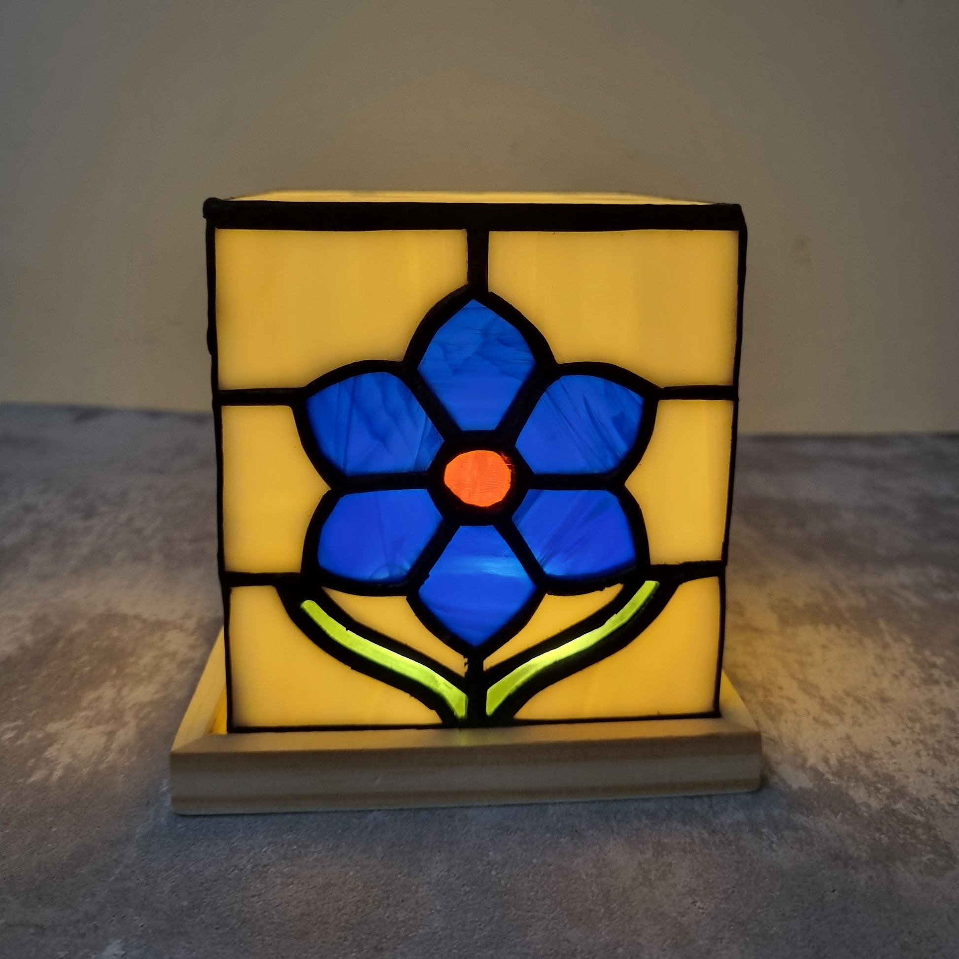 Decorative table light with stained glass design of a blue flower 