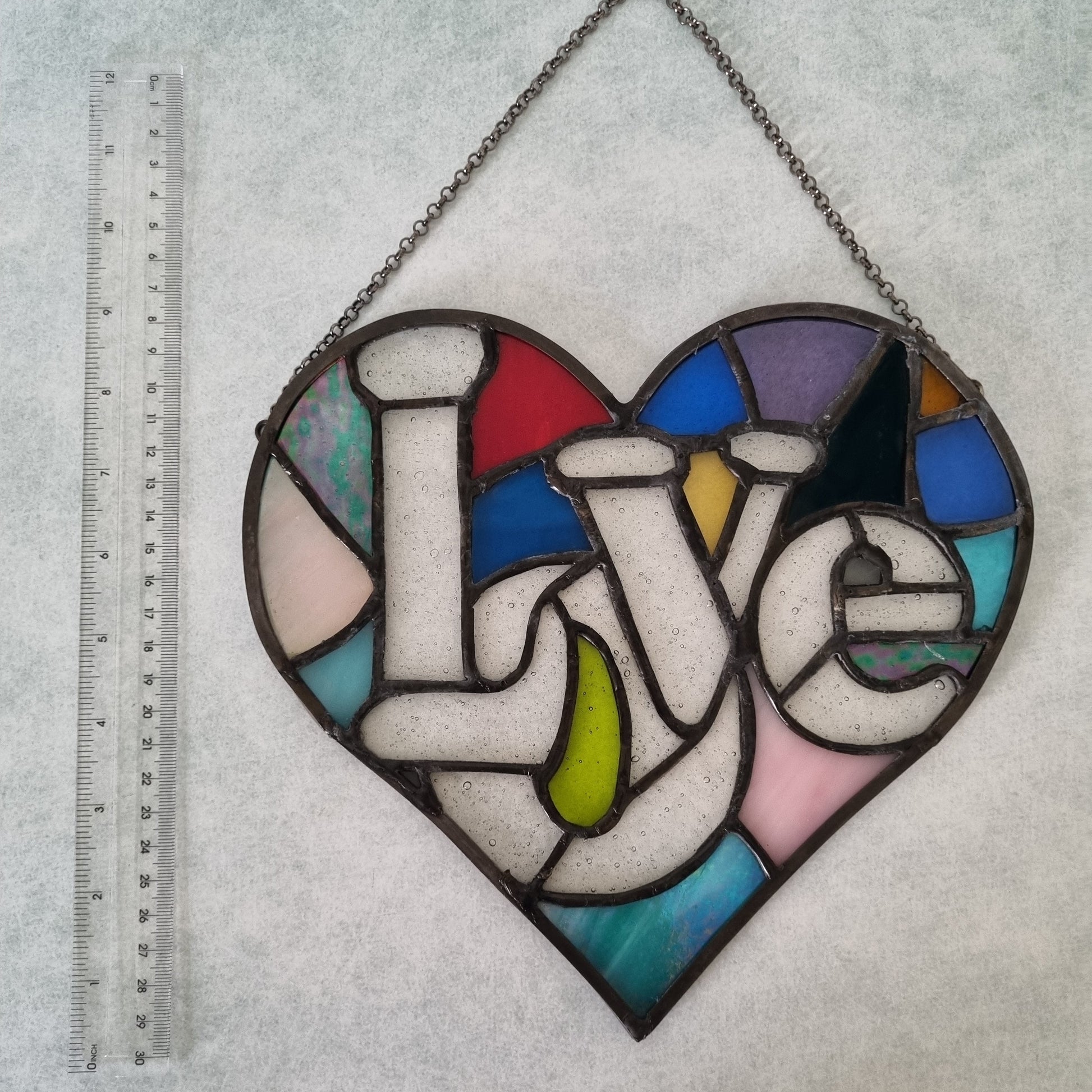 Handmade glass love heart – close up of heart and love word