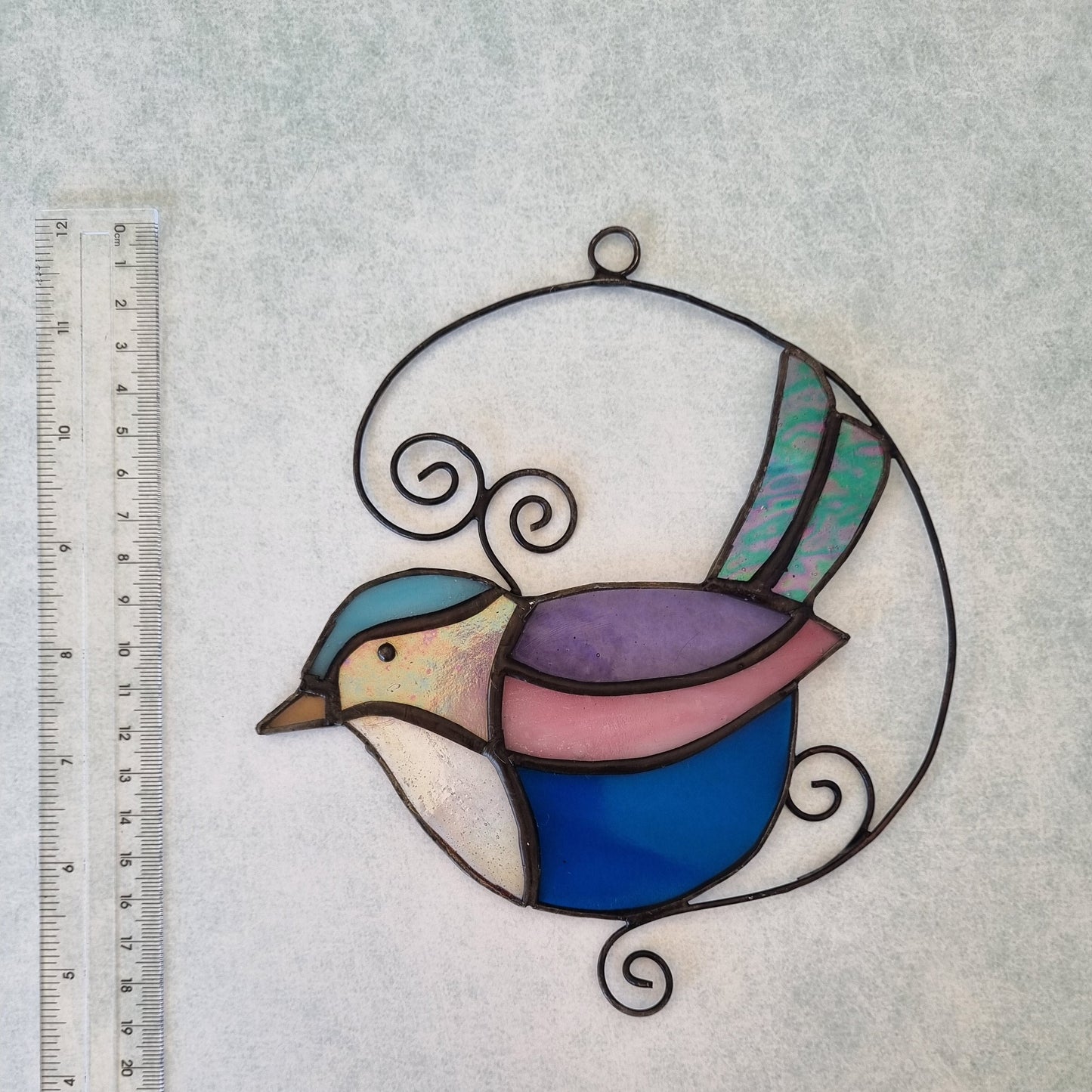 Handmade glass bird art – close up detail of colorful feathers