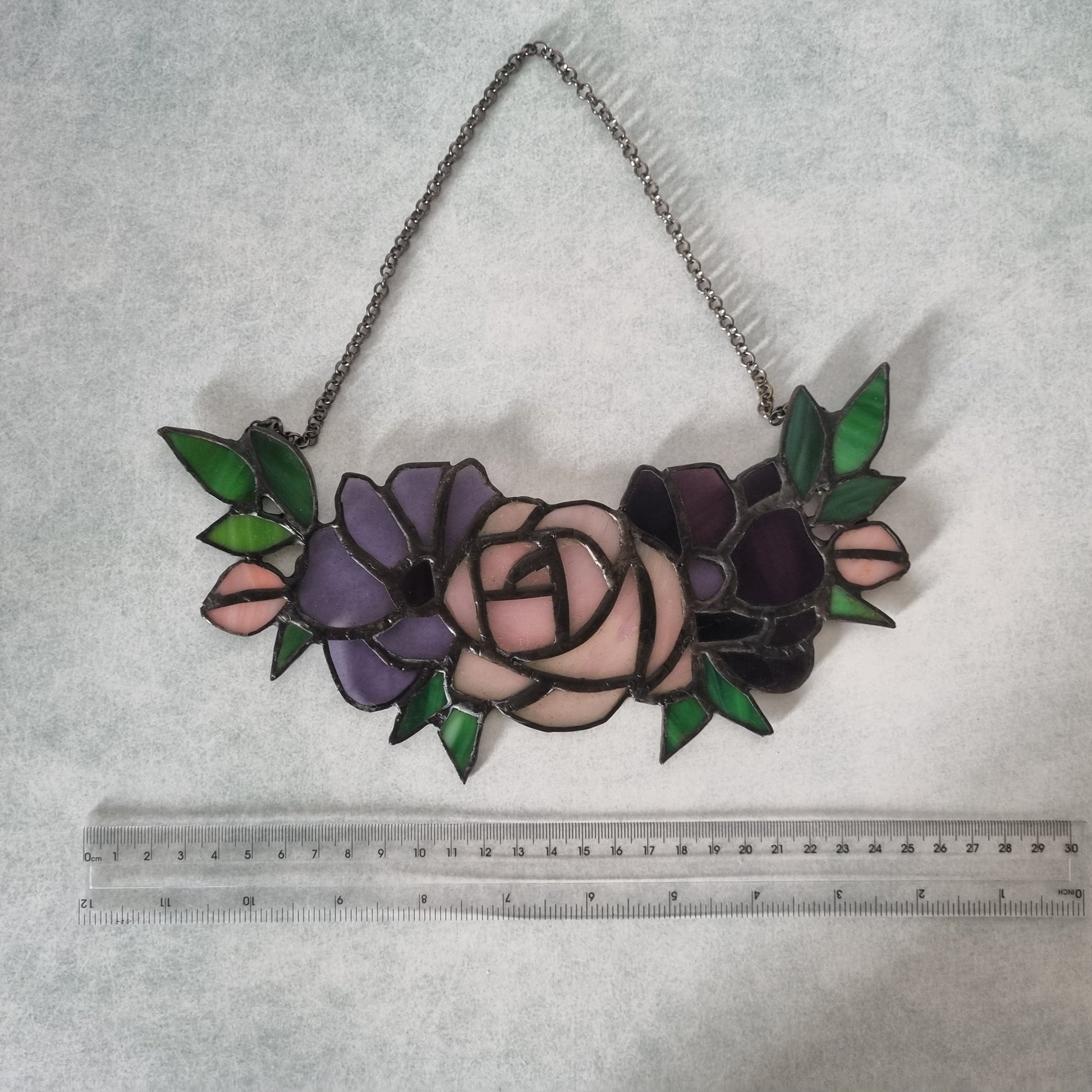 Purple stained glass flowers on a chain – close up detail