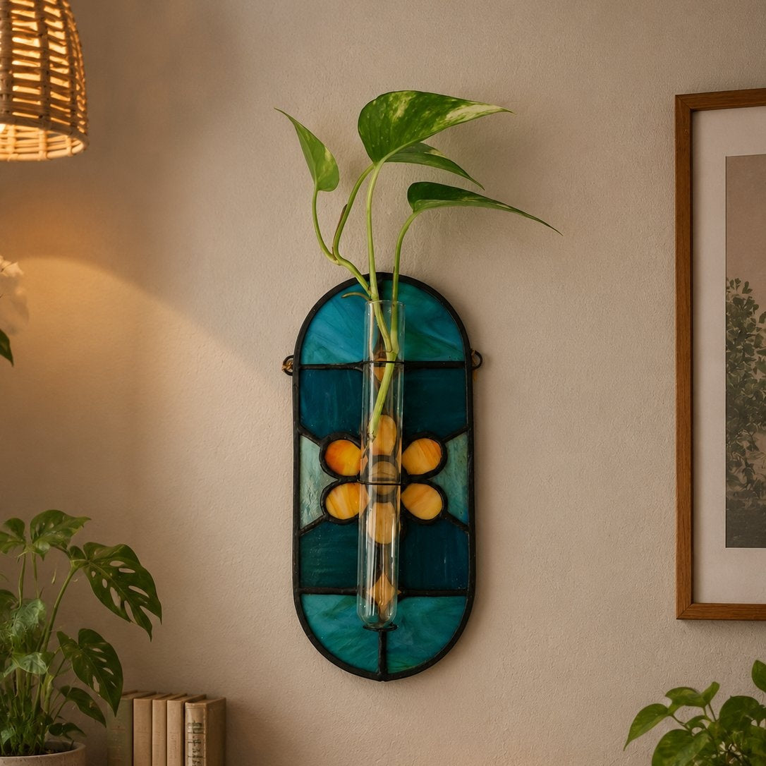 Decorative wall art with plants and books on a shelf against a beige wall.