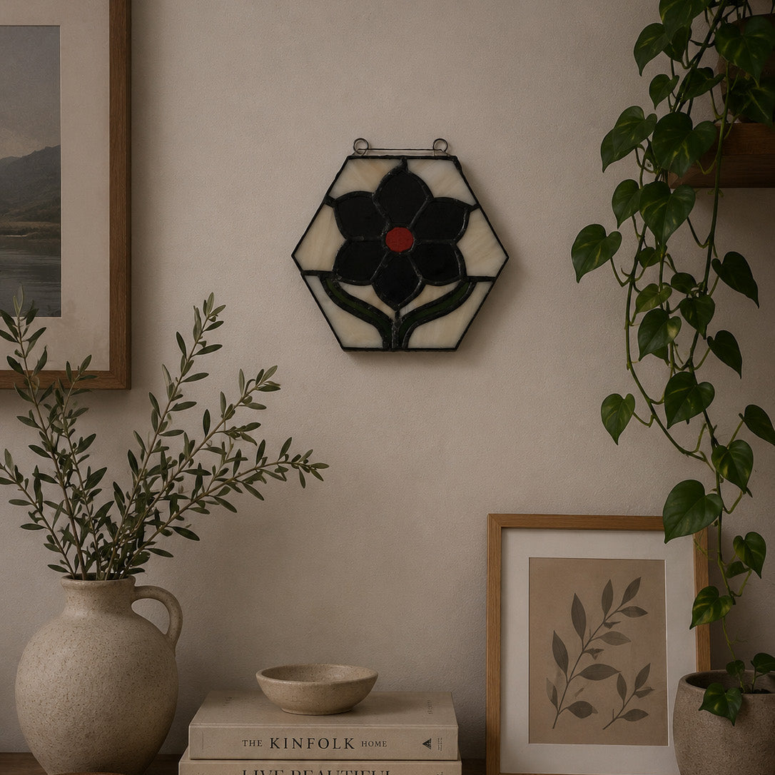 Decorative wall piece with a floral design, books, and plants on a wooden shelf.