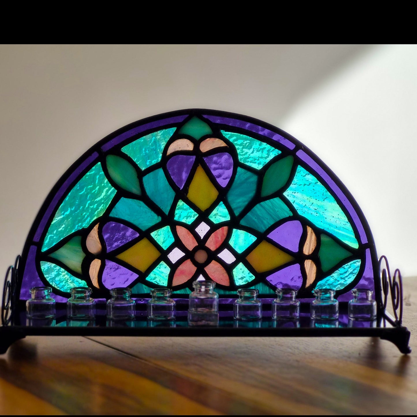Stained glass mandala menorah – side view with candles lit